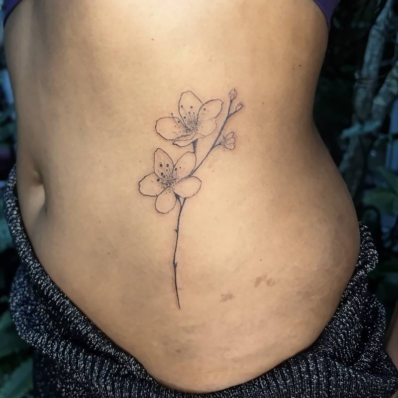 Fine line waist flower tattoo in Lisbon